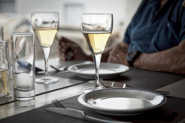 Man Waiting For His Date With Two Glasses Of White Wine On The Table. 