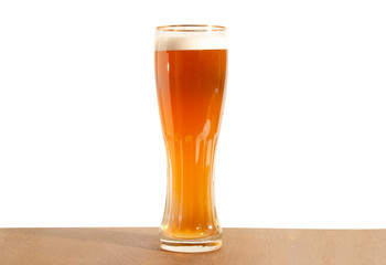 Light beer on the table on a white background. A tall glass beer glass.