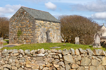Fototapeta na wymiar Stone house and cemetery with Celtic cross