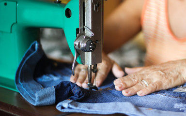 Sewing process - Women's hand behind her sewing. Vintage sewing machine isolated - Concept for needlework and tailoring.