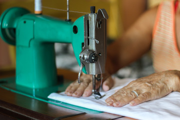 Sewing process - Women's hand behind her sewing. Vintage sewing machine isolated - Concept for...