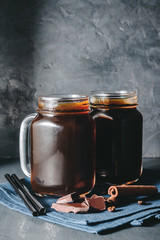 Coffee with ice in a glass mason jars on the napkin at dark background