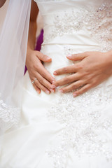 Obraz na płótnie Canvas bride holds hands on stomach. wedding day.