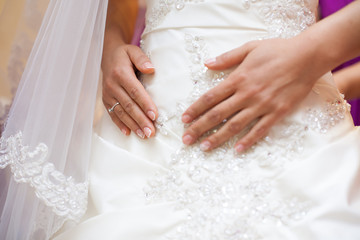 bride holds hands on stomach. wedding day.