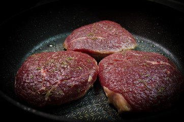 Raw beef steaks on the grill 