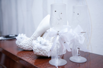 wedding accessories, glasses and brides shoes on the table