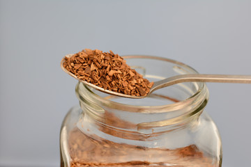 spoon with instant granulated coffee and bank filled with coffee