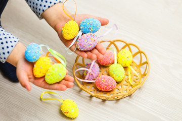 child girl holding basket with colorful Easter eggs