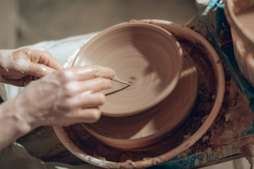 Cropped photo of male arms with stick over ceramic bowl
