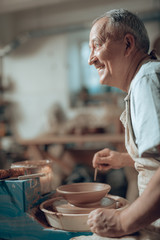 Side view of Caucasian craftsman working in potter's studio