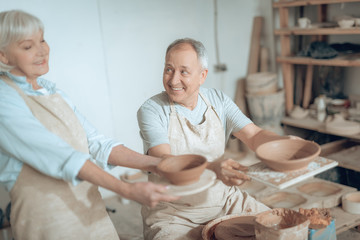High angle of two clay masters showing their works in potter's studio