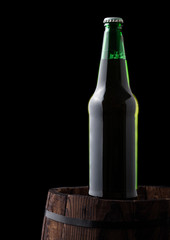 Cold bottle of craft beer on old wooden barrel