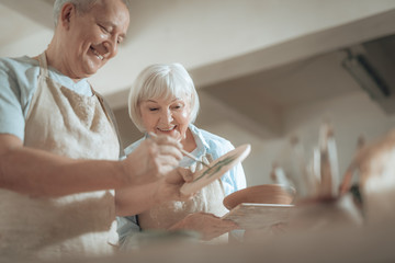 Cropped photo of elderly couple working in potter's studio