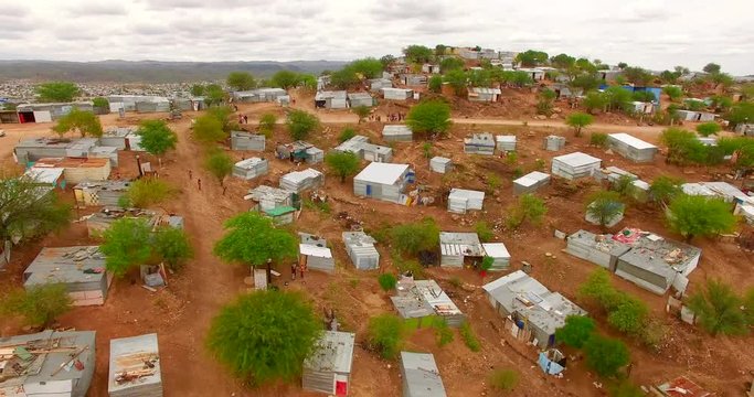 Fragile houses within harsh weather conditions and deserted terrain. Aerial 4K view of typical architecture in sub-Saharan Africa.