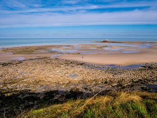 Elevated view of an ancient Fort on the waterline with beach rocks and pebbles in the foreground