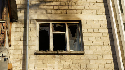 Fototapeta na wymiar View of the balcony and a broken window after the fire in block of flats