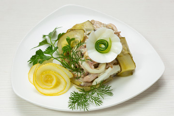 original salad with meat and pickled cucumbers, on a white plate