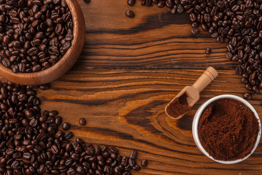 Roasted coffee beans and ground coffee and wooden spoone