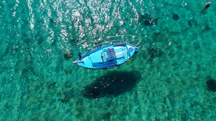 Aerial drone bird's eye view photo of traditional docked fishing boats near Naousa in island of Paros with deep emerald sea, Cyclades, Greece