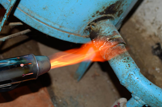 Heating a steel pipe with a blowtorch. The flame of a blowtorch