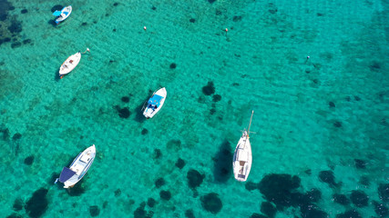 Obraz na płótnie Canvas Aerial drone bird's eye view photo of traditional docked fishing boats near Naousa in island of Paros with deep emerald sea, Cyclades, Greece
