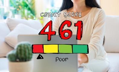 Poor credit score theme with woman using her laptop in her home office