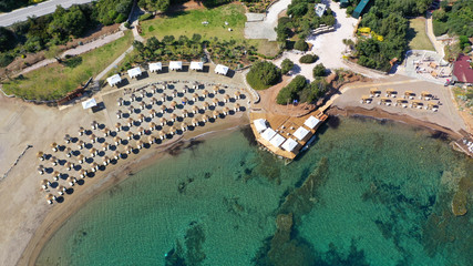 Aerial top view photo of sun beds in tropical paradise deep emerald mediterranean sandy beach