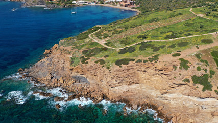 Aerial drone bird's eye view of archaeological site of Cape Sounio and magnificent Ancient temple of Poseidon on top of deep blue bay, South Attica, Greece