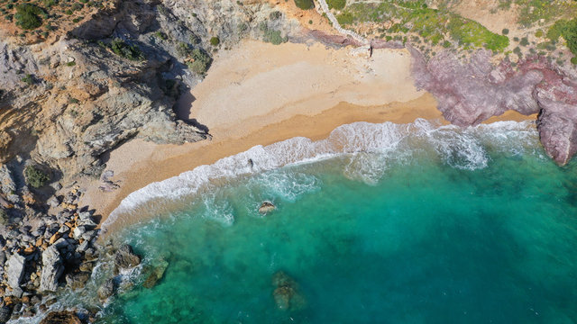 Aerial drone bird's eye view of famous emerald sea rocky beach of KAPE in area of Legrena, Sounio, Attica, Greece