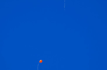 Multicolored balls, filled with helium, fly in the blue sky