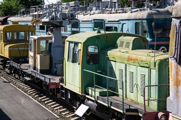 Old rusty steam locomotive beside a railway station platform. Retro train.