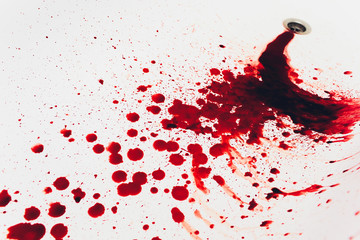 Blood draining from white bathroom basin. Bloody stains in the waterbasin hole. Sink run with blood...