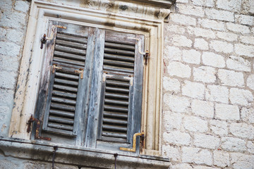 Wooden shutters and windows in old stone houses close-up.