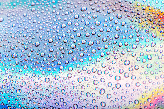 Drops of water on pastel holographic neon background