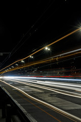 Fototapeta na wymiar long exposure of bright lights on road at night busy city