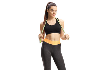 Fototapeta na wymiar Young fit female in sportswear with a skipping rope around her neck