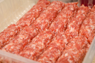Romanian uncooked meat rolls called mititei, mici - close-up. Romanian traditional food