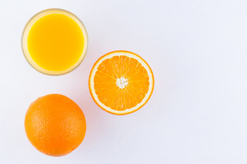 Orange fruits with juice, concept. Orange juice and halves of oranges on white background. Citrus for making juice. Whole and squeezed oranges and glass of juice