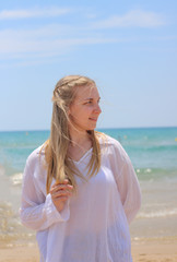 Fototapeta na wymiar Pretty blonde woman posing on the beach