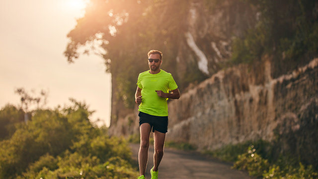 Man Jogging On A Downhill / Uphill In Suburb Mountain Road.