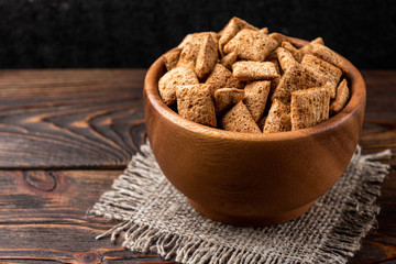 Breakfast dried chocolate pads on dark wooden background. 