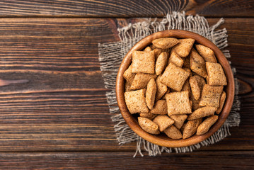 Breakfast dried chocolate pads on dark wooden background. 