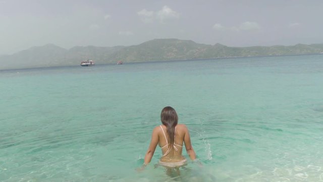 Slow Motion: A Bikini-Clad Young Woman Plays in the Crystal Blue Ocean in Chouchou Bay, Haiti