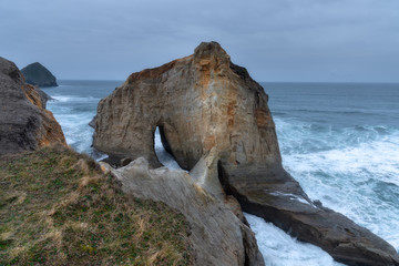 ocean cliffs on a dark, dramatic, moody day with interesting rock formations