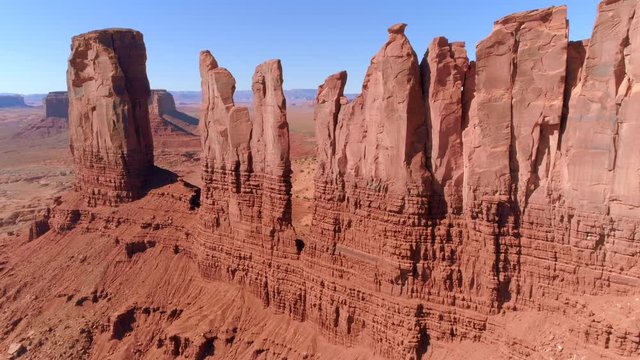 Inspiring red planet aerial view. Slower approaching the sheer, flat ginger cliffs at Monument Valley. Wild WIld West movies filing location, Utah and Arisona states border, USA. 4K drone footage.