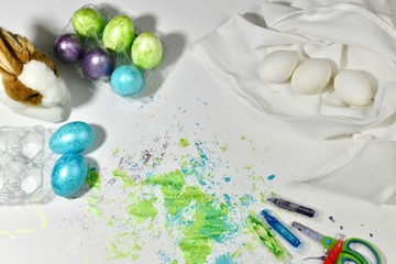 Easter traditions. Painting eggs on the working surface. Painted and white eggs.