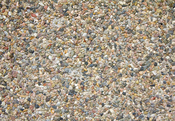 Colorful abstract background of small pebbles and stone embedded in cement. Texture