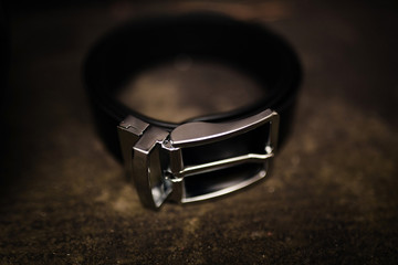 men's black uniform for pants. black leather belt. fashion leather belt on wooden background with...