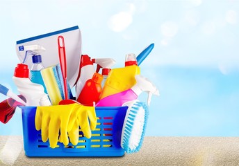 Plastic bottles, cleaning sponges and gloves on blue background