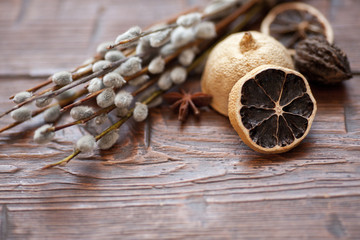 Willow catkins with spices on wooden background. Easter concept.